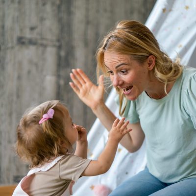 Happy mother talking whit her baby girl at home