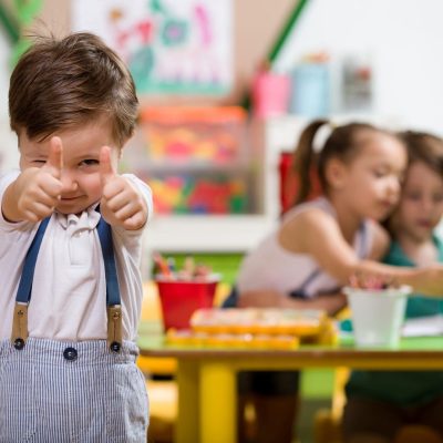 Happy little boy posing in classroom.